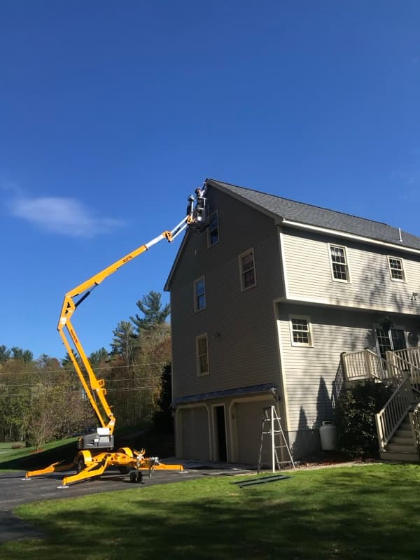 Exterior painting of a large home with boom lift in Salem, NH