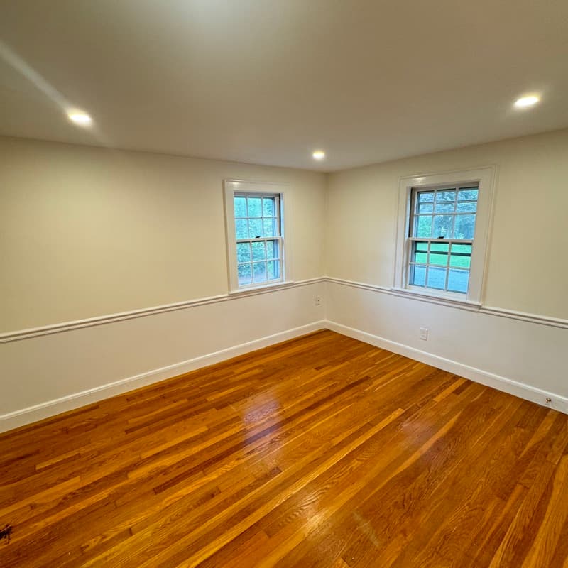 Freshly painted room with cream walls, wainscoting, and hardwood floors in Lynnfield, MA