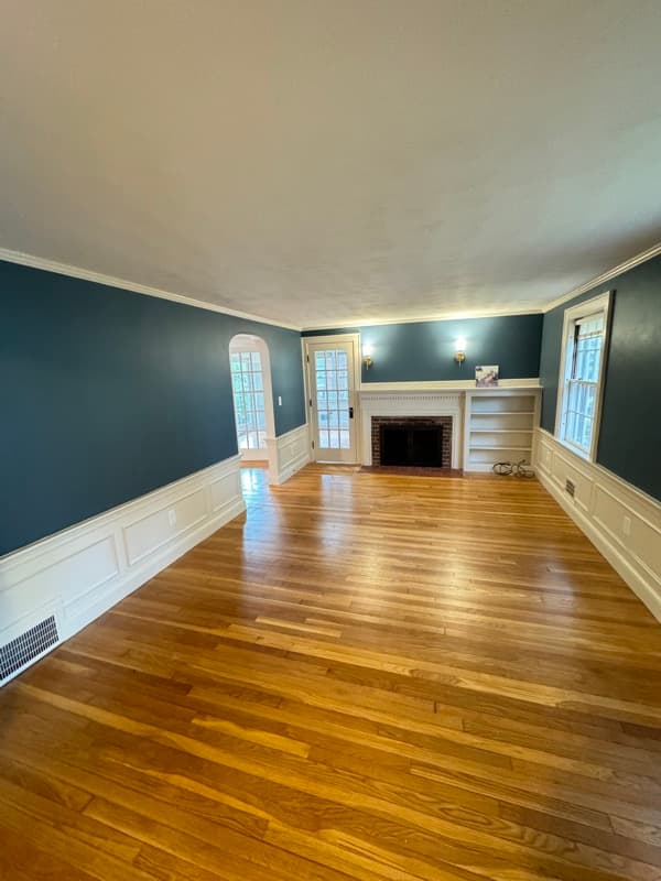 Living room with teal accent wall, white built-ins, and fireplace in Lynnfield, MA