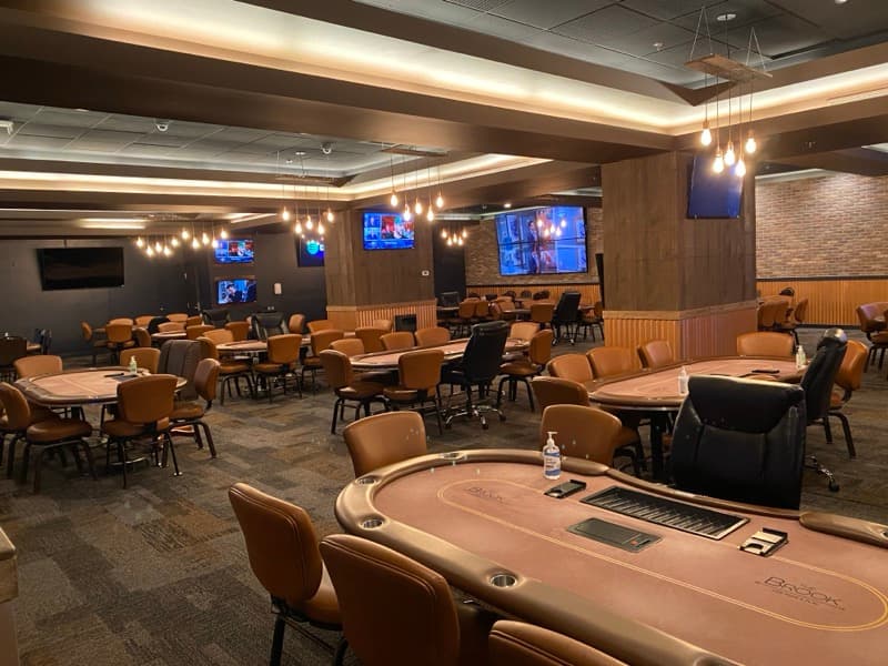 Commercial gaming room with painted walls, brick accent, and pendant lighting in Seabrook, NH